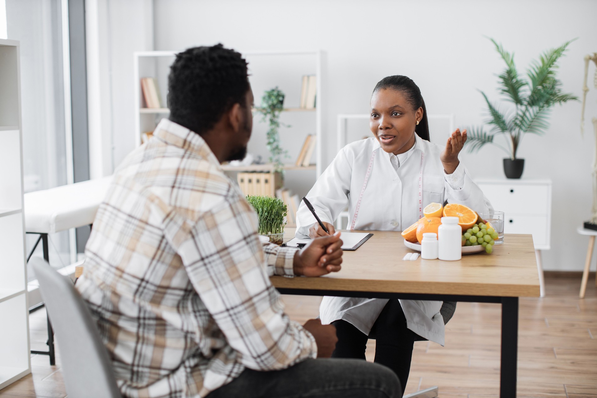 Expert in nutrition talking to man in consulting room